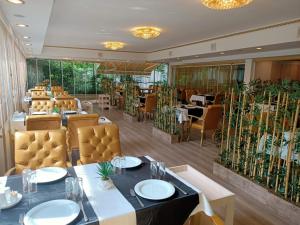 a dining room with tables and chairs and plants at Twins Hotel in Ankara