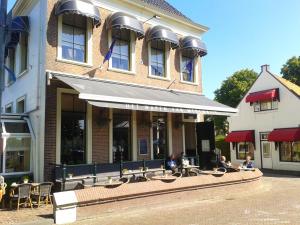 un edificio con tavoli e sedie di fronte di Hotel Medemblik a Medemblik
