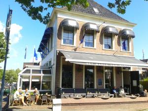 mensen aan tafels buiten een gebouw bij Hotel Medemblik in Medemblik