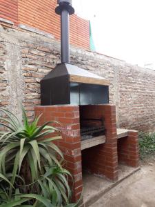 un forno di mattoni posto accanto a un muro di Casa El Quisco a El Quisco 1 altra foto