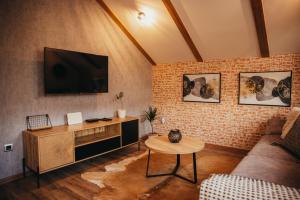 ein Wohnzimmer mit einem TV an einer Backsteinwand in der Unterkunft Villa Magnolia in Sveti Martin na Muri