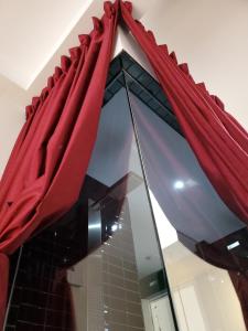 a mirror with red curtains in a bathroom at Hotel Chez Swann in Montreal