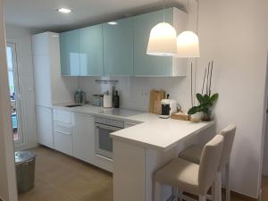 a kitchen with blue cabinets and a white counter top at Apartamento La Sirenita in Rota