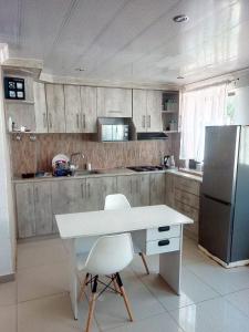 een keuken met een witte tafel en een koelkast bij 54 Malcolm Palace Room in Durban