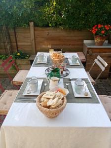 uma mesa com pratos de comida e um cesto de pão em clos st Joseph em Oullins