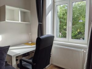 Habitación con escritorio, silla y ventana. en ClearVueHome - Green Studio 10min to Vienna Center, en Viena