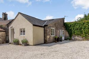 an exterior view of a stone house with a driveway at Little Doric in Shepton Mallet