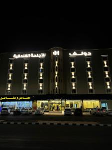 a building with cars parked in a parking lot at night at Doolv Hotel in Hail