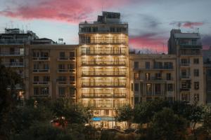 un grand bâtiment avec des lumières allumées devant lui dans l'établissement Esperia, à Thessalonique