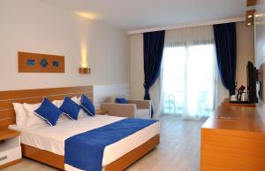 a hotel room with a bed with blue pillows at Jasmin Beach Hotel in Gümbet +57 photos