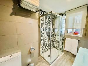 baño con ducha y puerta de cristal en Apartamento Puerta Carmona, en Sevilla