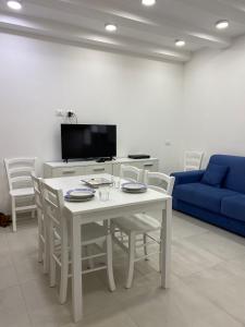 salon ze stołem i krzesłami oraz niebieską kanapą w obiekcie Zaras 11 w mieście Ischia