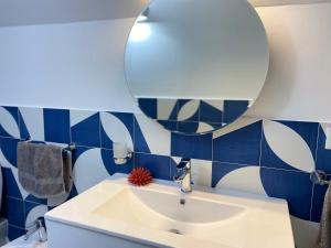 ein Badezimmer mit einem weißen Waschbecken und einem Spiegel in der Unterkunft Zaras 11 in Ischia