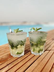 two glasses with plants in them sitting on a table at AP Cabanas Beach & Nature - Adults Friendly in Cabanas de Tavira