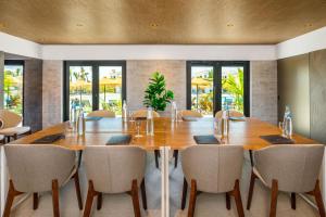 a dining room with a large wooden table and chairs at AP Cabanas Beach & Nature - Adults Friendly in Cabanas de Tavira