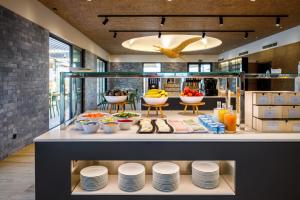 a counter with plates and bowls of food on it at AP Cabanas Beach & Nature - Adults Friendly in Cabanas de Tavira