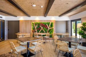a room with tables and chairs and a painting on the wall at AP Cabanas Beach & Nature - Adults Friendly in Cabanas de Tavira