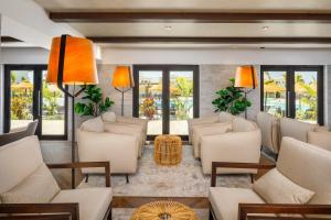 a living room with white furniture and windows at AP Cabanas Beach & Nature - Adults Friendly in Cabanas de Tavira