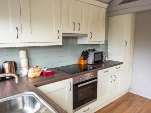 Two Dales1 Bed Studio in Two Dales Near Matlock & Bakewell的带白色橱柜和水槽的厨房
