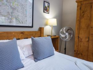 Two Dales1 Bed Studio in Two Dales Near Matlock & Bakewell的卧室配有白色的床、风扇和风扇。