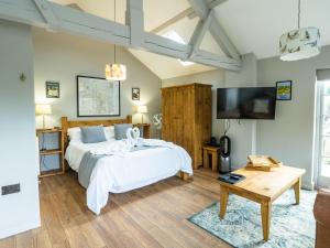 Two Dales1 Bed Studio in Two Dales Near Matlock & Bakewell的一间带床和平板电视的卧室