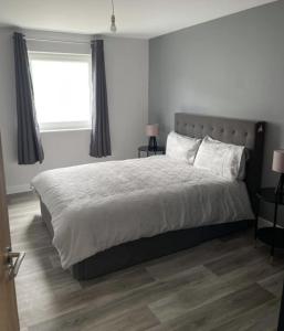 um quarto com uma cama grande e uma janela em Lochaber Apartments em Fort William