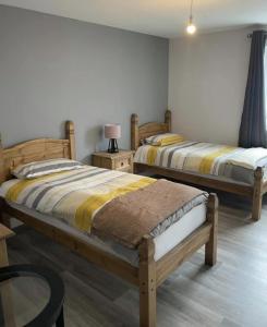 um quarto com 2 camas e uma mesa com um candeeiro em Lochaber Apartments em Fort William