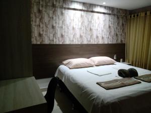 a bedroom with a large bed with a wooden headboard at Jardins do Atlântico Cabo Branco Beira-Mar in João Pessoa