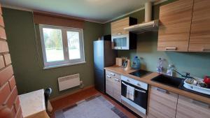 a kitchen with a refrigerator and a sink at Vakari Puhketalu in Vakari