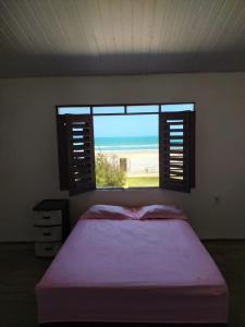 - une chambre avec un lit et une vue sur l'océan dans l'établissement Casa de Praia no Morro Branco, à Beberibe