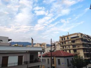 een uitzicht op een stad met gebouwen en een bewolkte lucht bij Sophie's Guest House in Volos