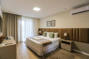 a hotel room with a large bed and a window at Estaleiro Guest House in Balneário Camboriú