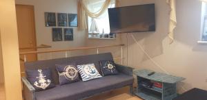 a living room with a couch and a flat screen tv at Tähe Holiday Home in Pärnu