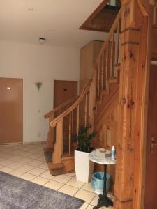 einen Flur mit Holztreppe in einem Haus in der Unterkunft Hotel Bölke in Wunstorf