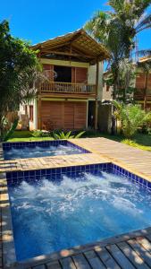 a swimming pool in front of a house at Taipu de Fora - Casa Charme in Barra Grande