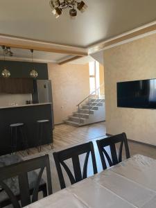 a dining room with a table and chairs and a kitchen at Guest House VELVET in Tsaghkadzor
