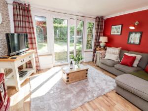 a living room with a couch and a tv at Old Pump Cottage in Ross on Wye