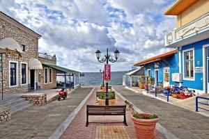 a boardwalk next to the water with buildings at Harmony House Marathopoli 2 in Marathopoli