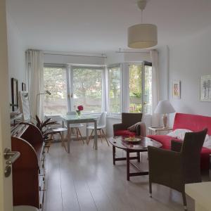 a living room with a red couch and a table at Hamburg Niendorf-Suite in Hamburg