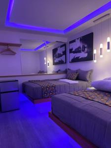 a bedroom with two beds with purple lights at Alegria Hostal in Santiago de los Caballeros