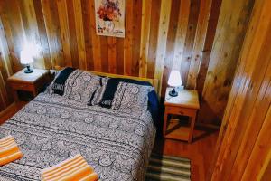 a bedroom with a bed and two lamps on tables at Cabañas simple Pucon in Pucón