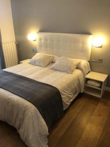 - une chambre avec un grand lit blanc et 2 oreillers dans l'établissement CR Luarri, à Saint-Sébastien