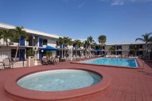 une grande piscine avec des chaises et un complexe dans l'établissement Days Inn by Wyndham St. Petersburg / Tampa Bay Area, à St Petersburg