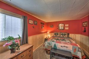 - une chambre avec des murs rouges, un lit et une fenêtre dans l'établissement Woodsy Riverfront Retreat in Trout Creek Montana!, à Trout Creek