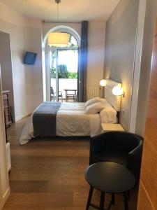1 dormitorio con 1 cama, 1 silla y 1 ventana en CR Luarri, en San Sebastián