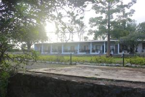 a building with a stone wall in front of it at Singaras Coffee Country in Masinagudi