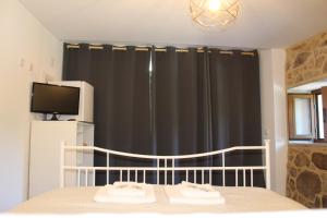 a bedroom with a bed and a black curtain at Suite das Fraguinhas in Sistelo