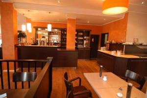 ein Restaurant mit Tischen und Stühlen und einer Bar in der Unterkunft Hotel Sprenz in Oldenburg