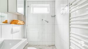 un bagno bianco con vasca e lavandino di Hamburg Niendorf-Suite ad Amburgo