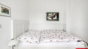 un letto bianco in una stanza bianca con sopra delle mele di Hamburg Niendorf-Suite ad Amburgo